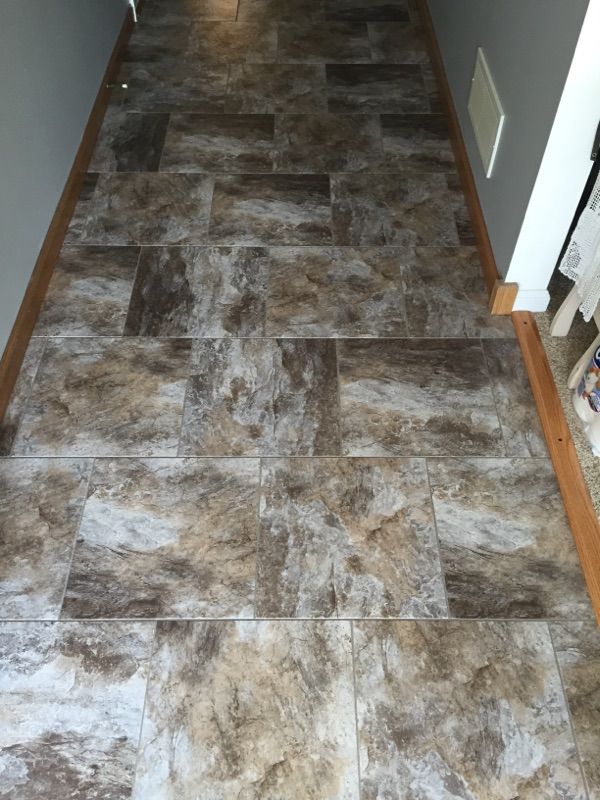 A hallway with a tiled floor and a wooden trim