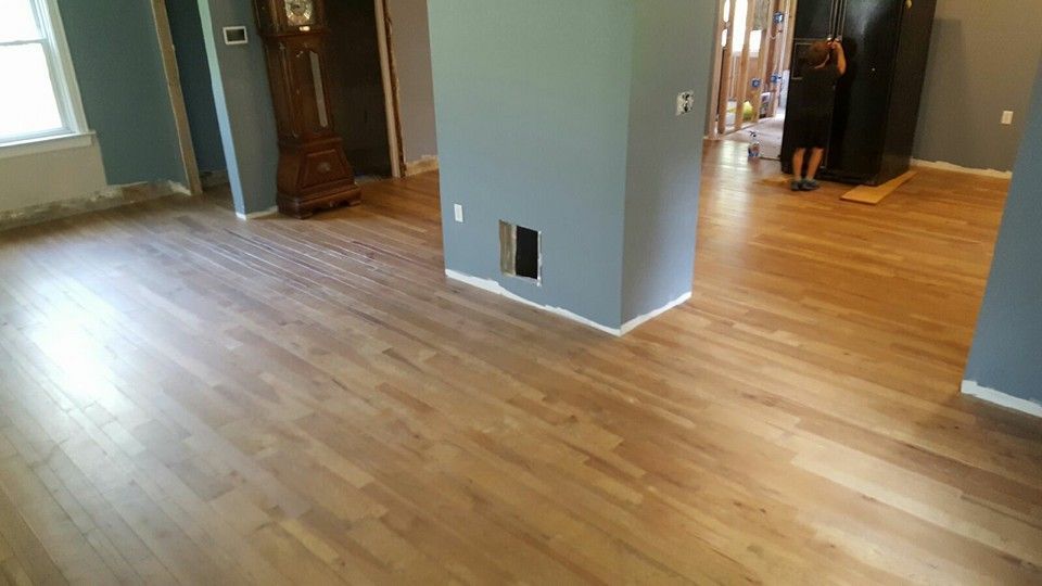 A living room with hardwood floors and a clock on the wall.