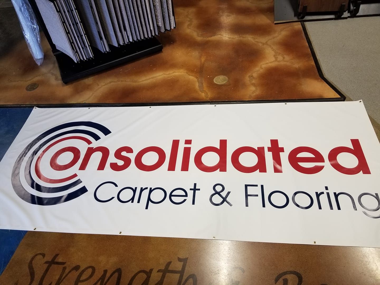 A banner for consolidated carpet and flooring is on the floor
