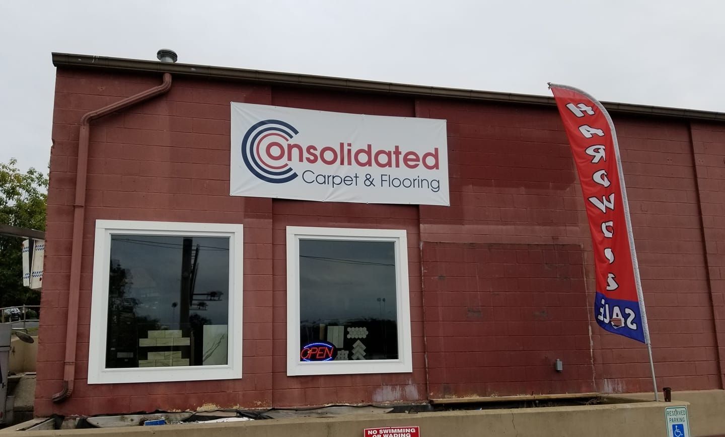 A red building with a sign that says consolidated carpet & flooring
