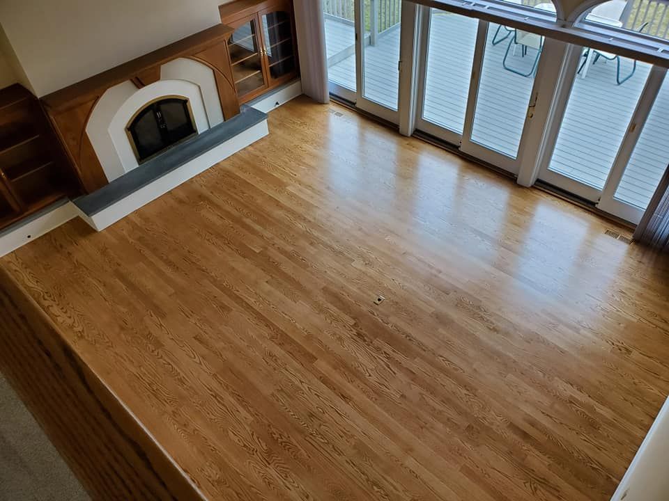 An aerial view of a living room with hardwood floors and a fireplace.