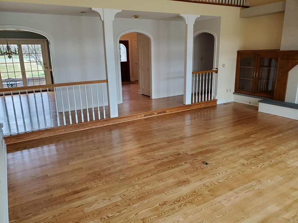 An empty living room with hardwood floors and stairs