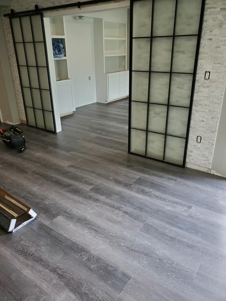 A living room with hardwood floors and sliding barn doors.
