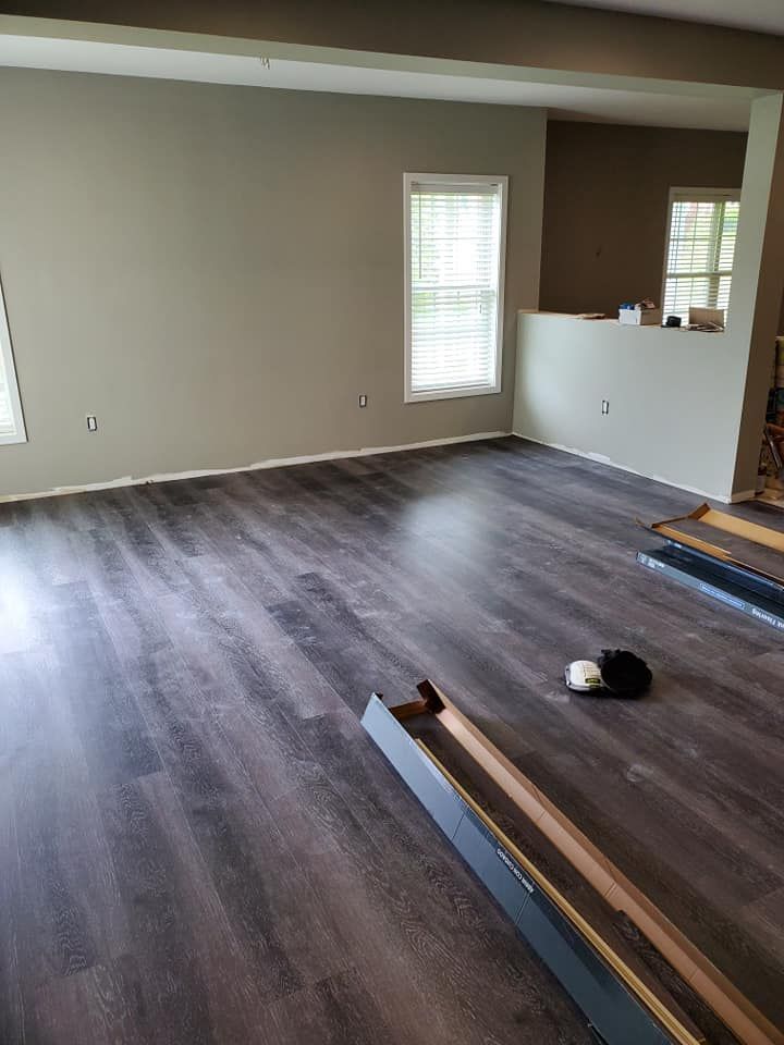 A living room with hardwood floors and a cat laying on the floor.
