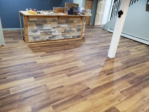 A room with a wooden floor and a stone wall.