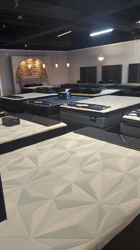 A room filled with lots of mattresses in a store.