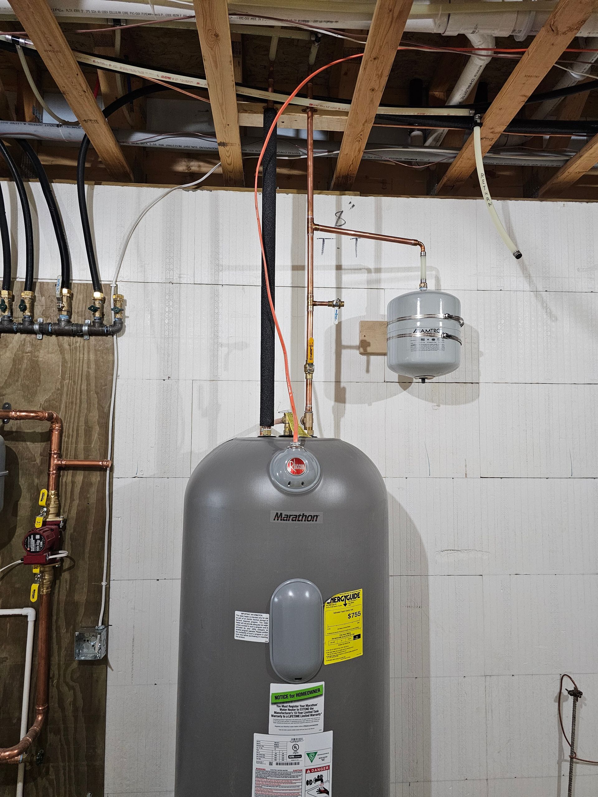 Gray water heater and white expansion tank in a basement with exposed ceiling beams and pipes.