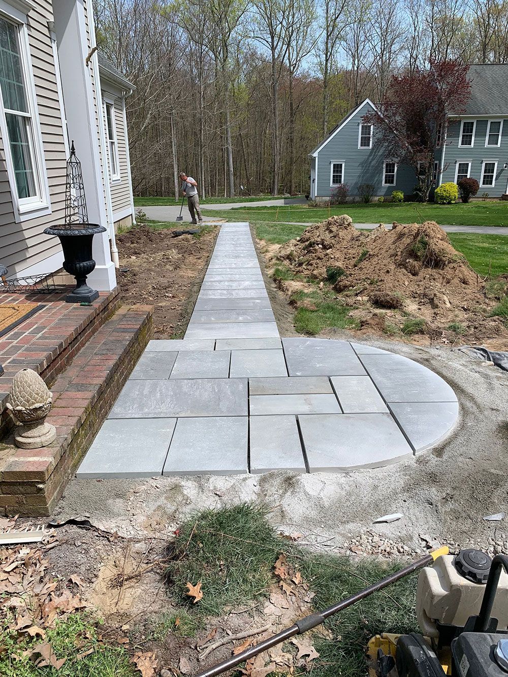 A concrete walkway is being built in front of a house