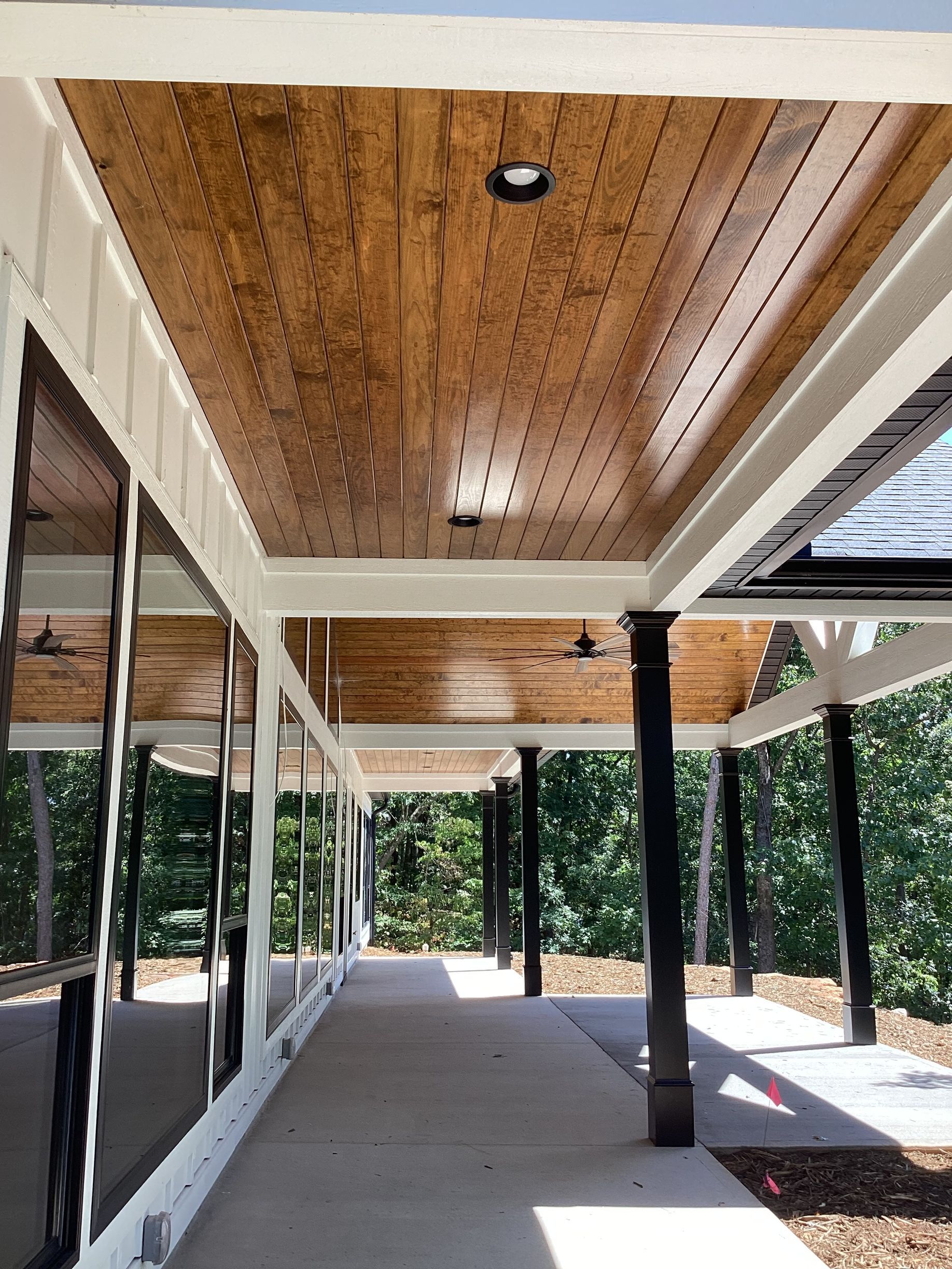 A long walkway between two buildings with a wooden ceiling.