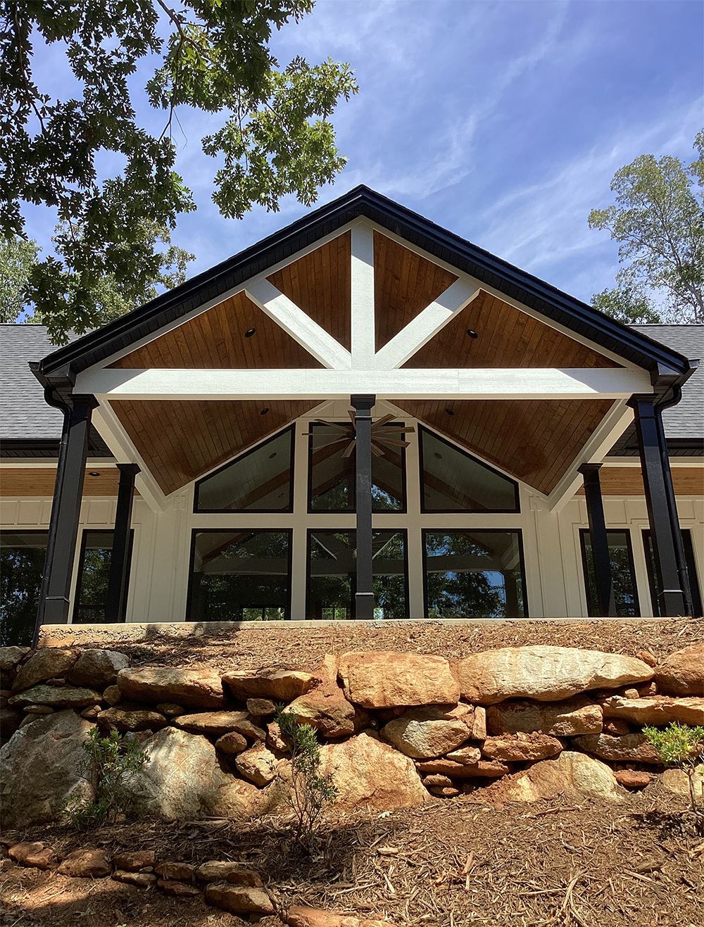 A large house with a lot of windows is sitting on top of a rocky hill.