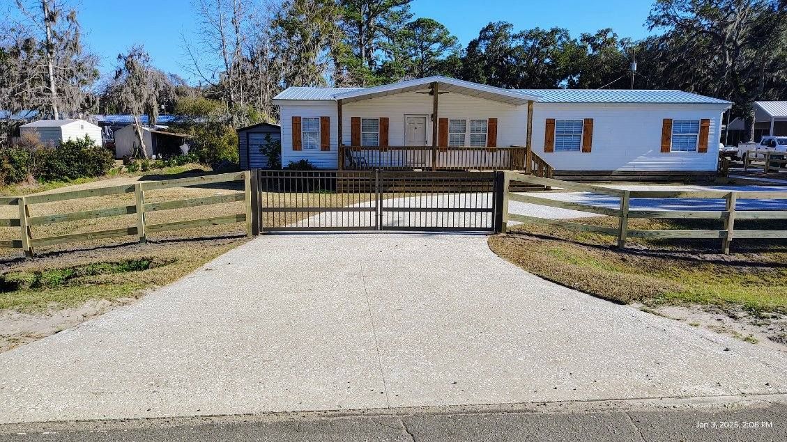 A mobile home with a gravel driveway leading to it.