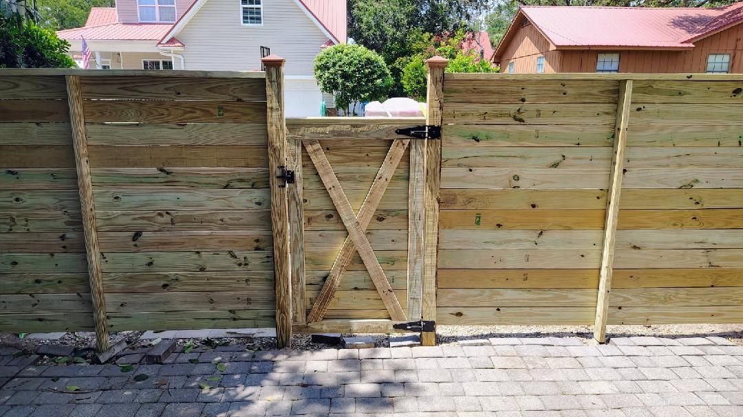 Wooden fence with gate; gate features an