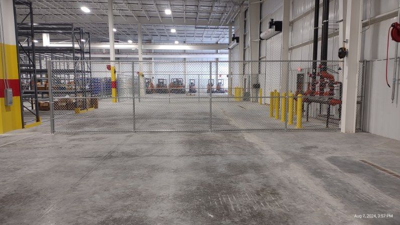 A large warehouse with a chain link fence in the middle of it.