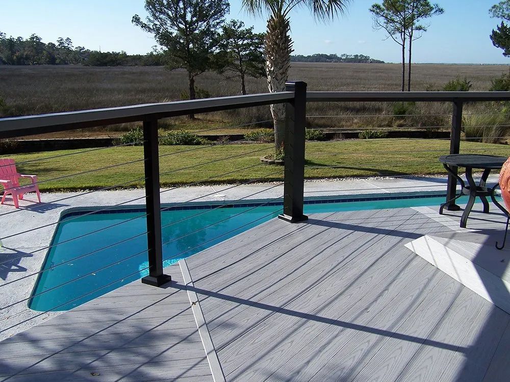 a deck with a swimming pool in the background