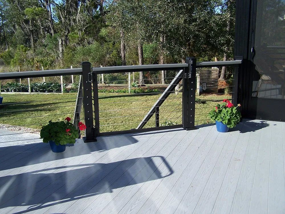a deck with a fence and flowers on it