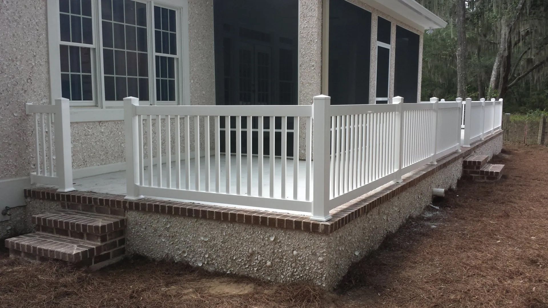 a house with a screened in porch and a white railing