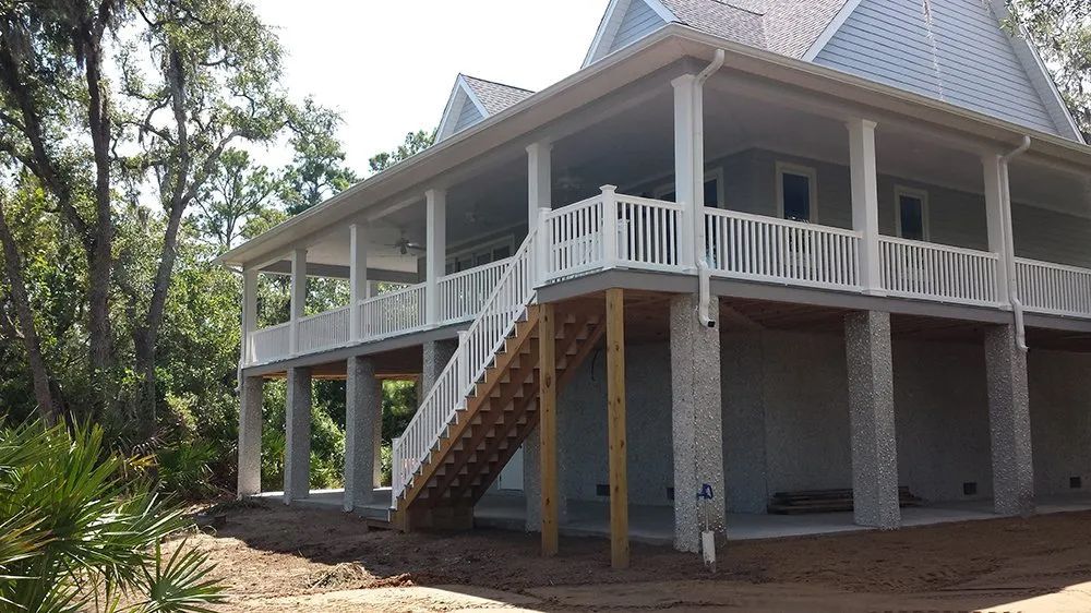 a white house with a large deck and stairs