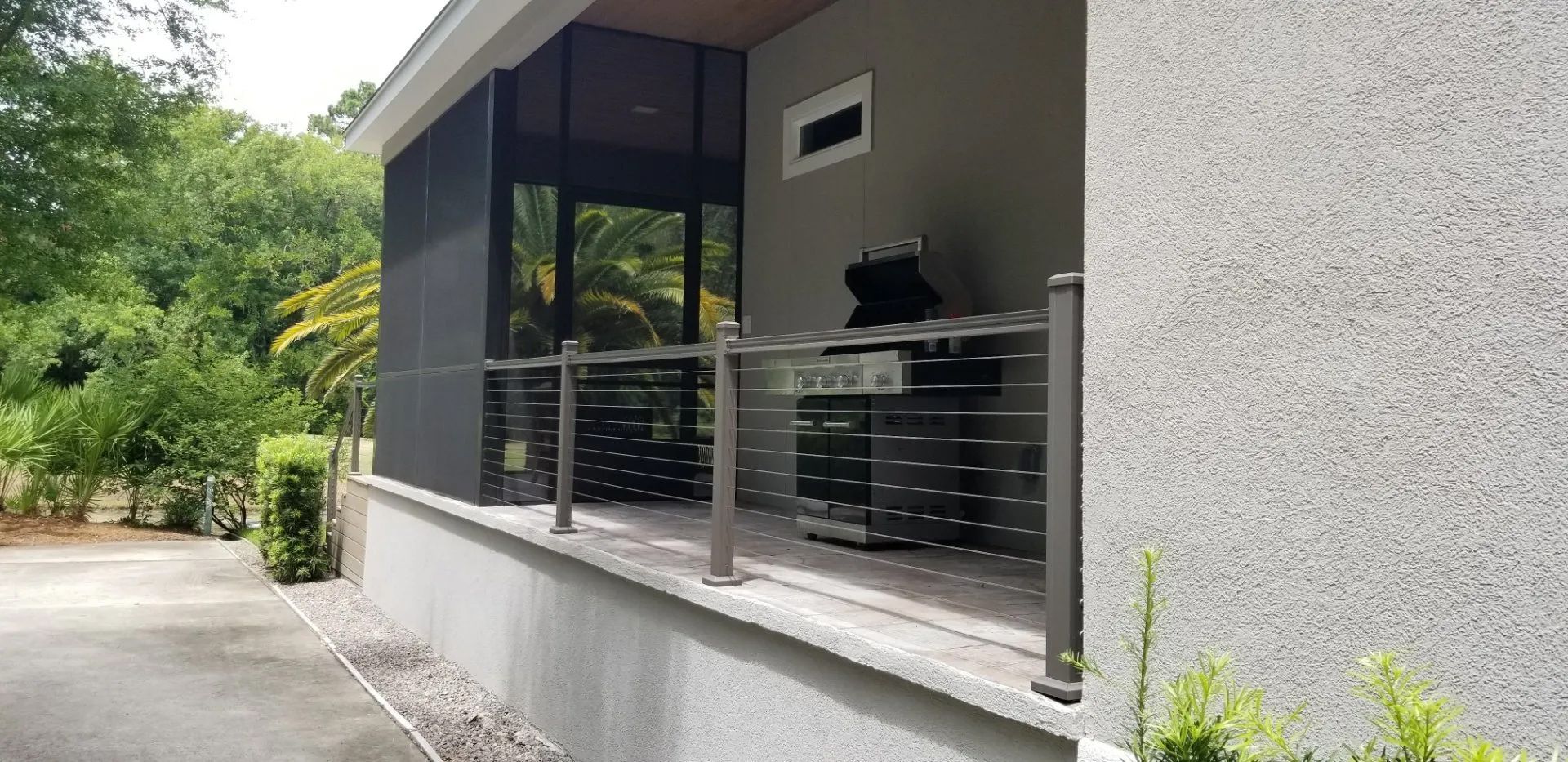a house with a screened in porch and a grill on it
