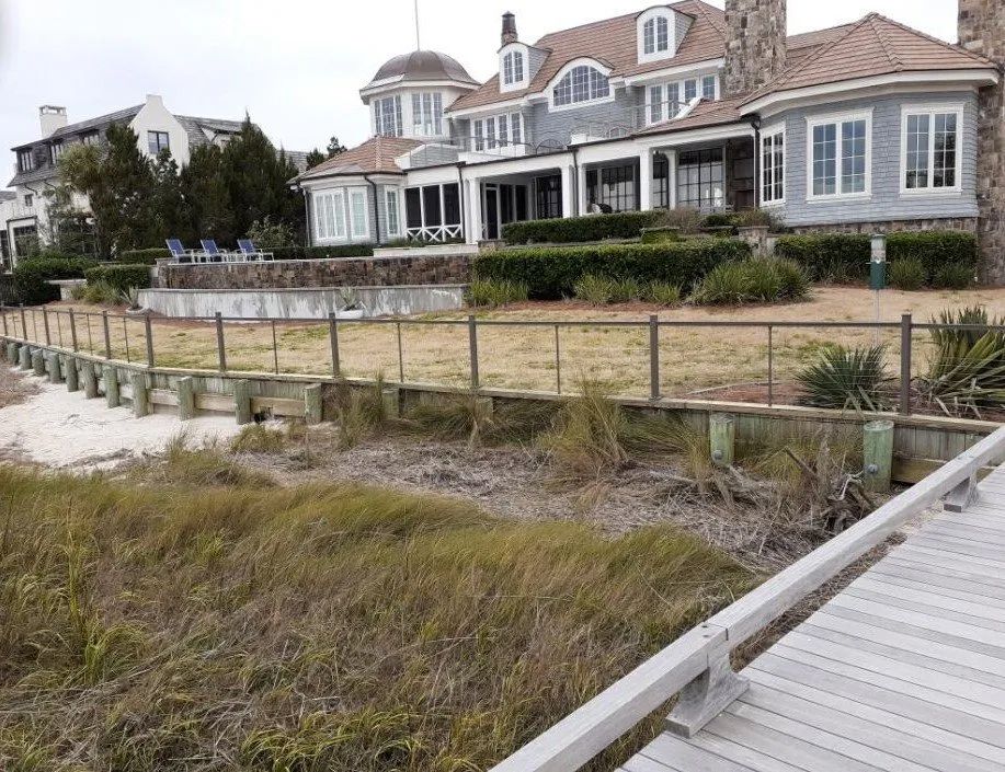 a large house with a lot of windows is behind a fence
