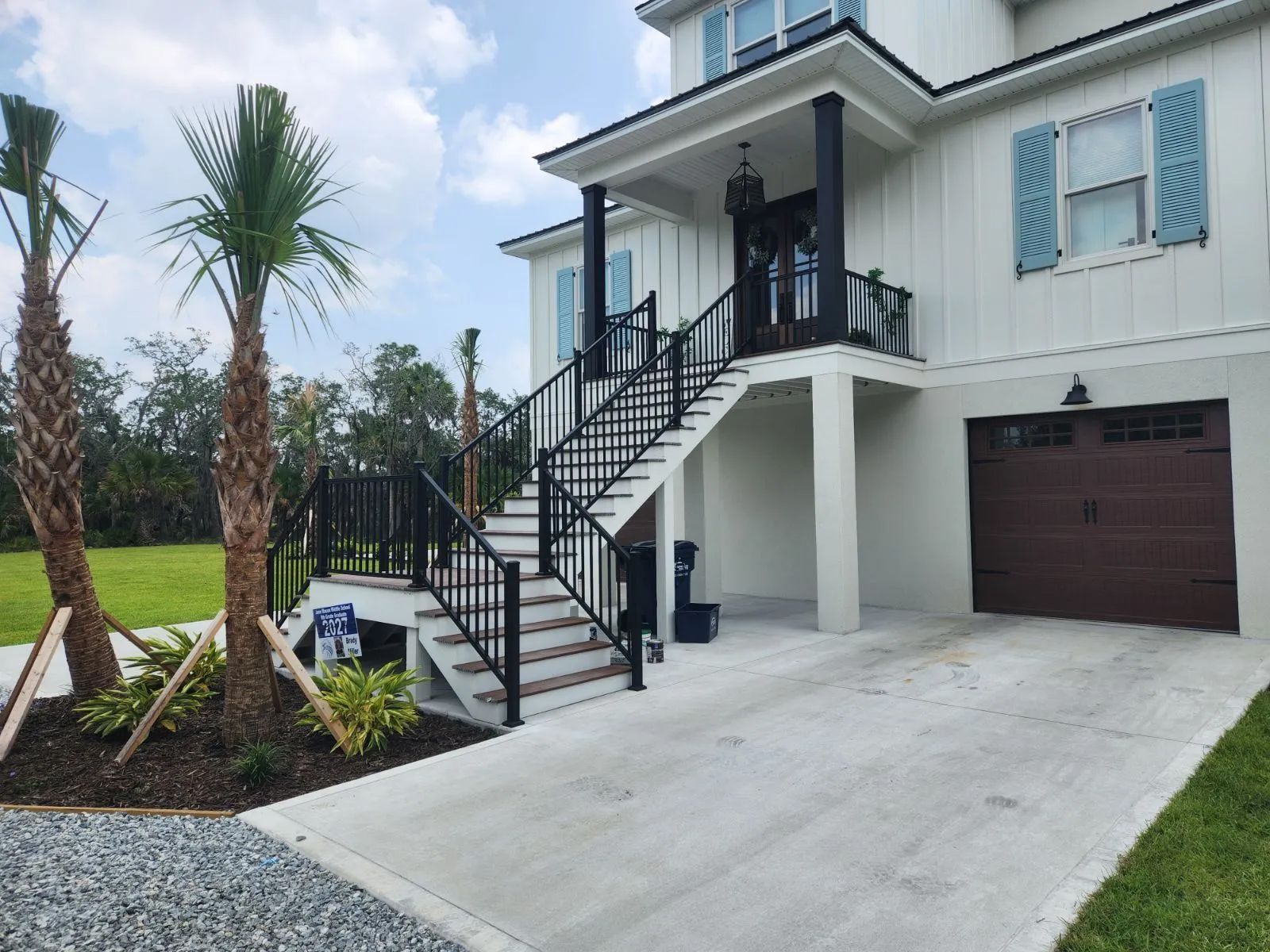 a white house with stairs leading up to the second floor