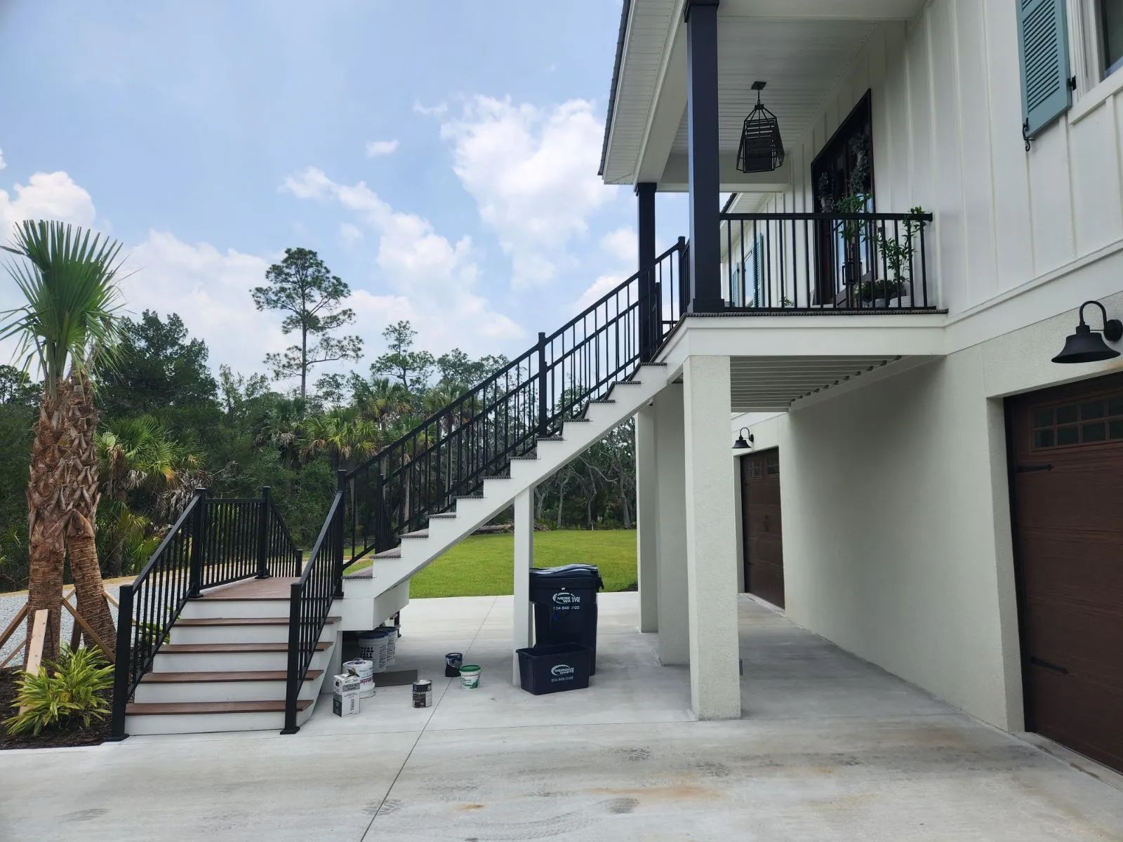 a white house with stairs leading up to the second floor