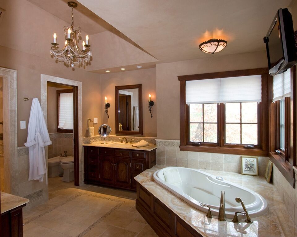 A bathroom with a large tub and a chandelier hanging from the ceiling