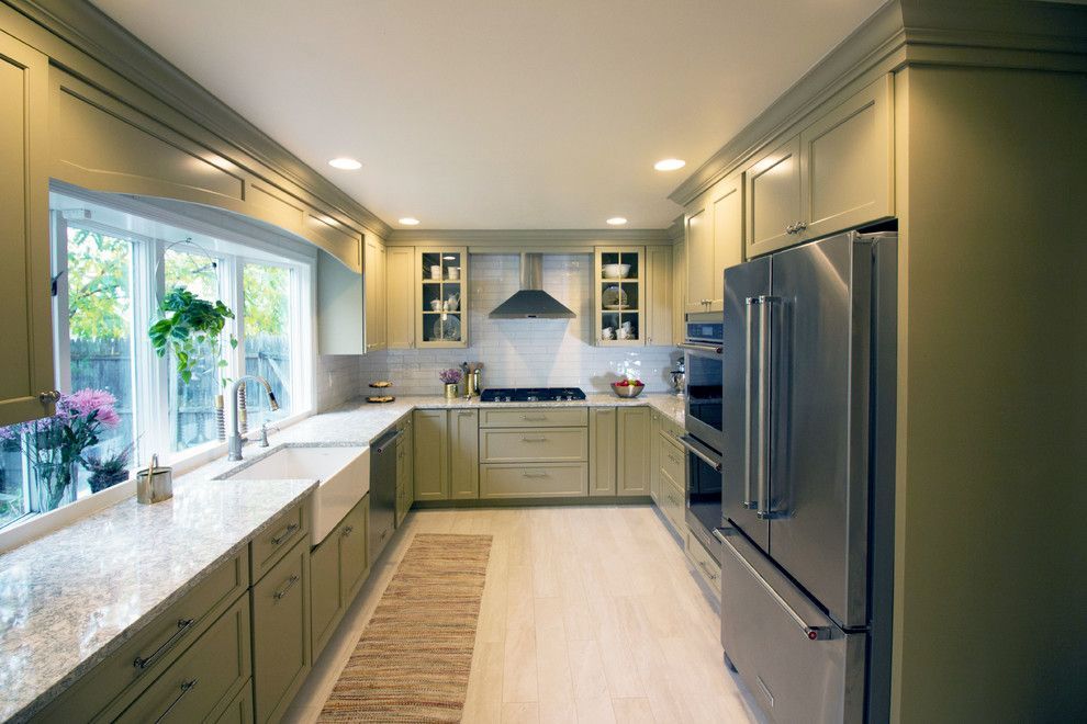 A kitchen with stainless steel appliances and green cabinets