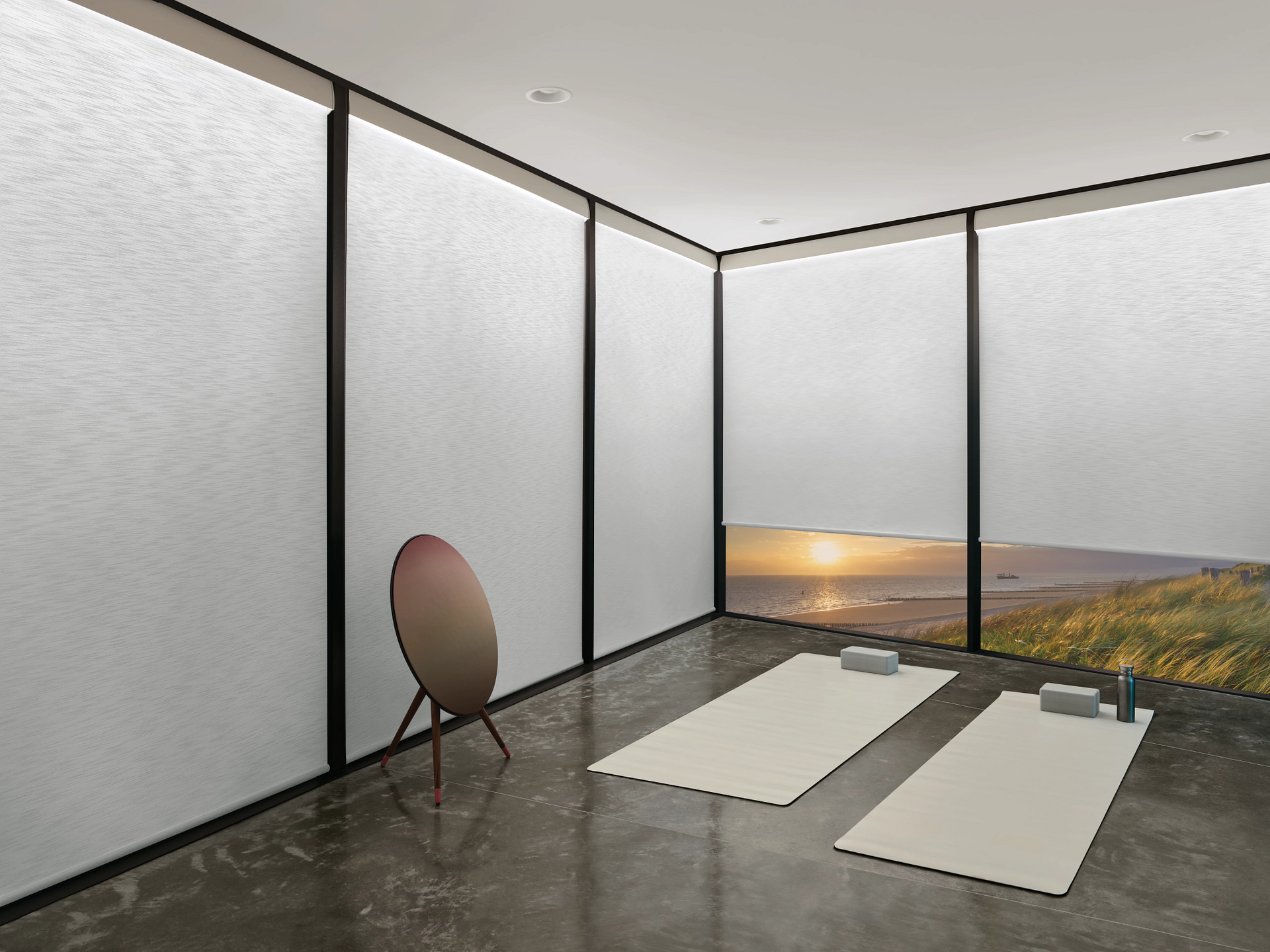 A room with a lot of windows and two yoga mats on the floor.