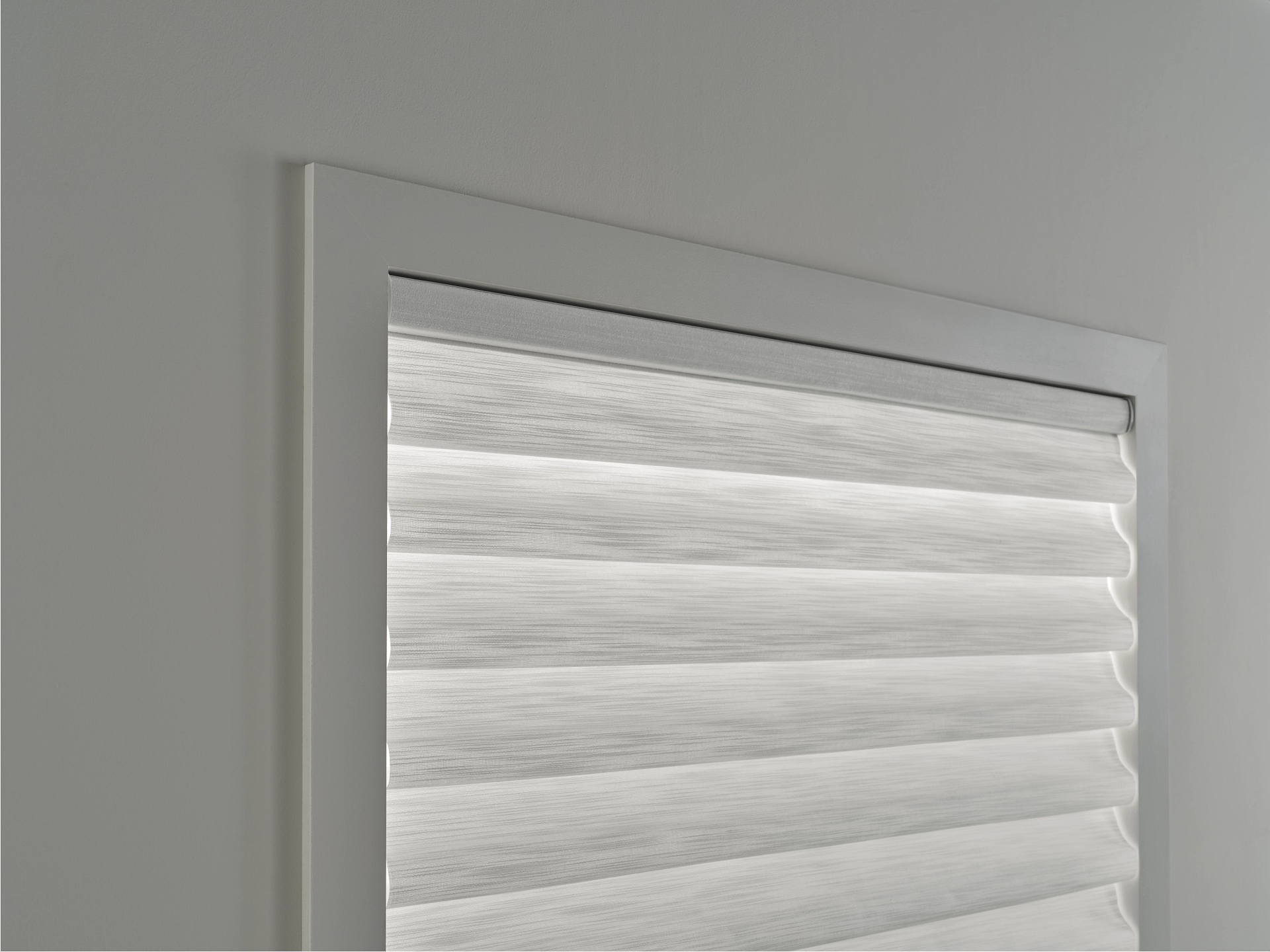 A close up of a white blind on a window.