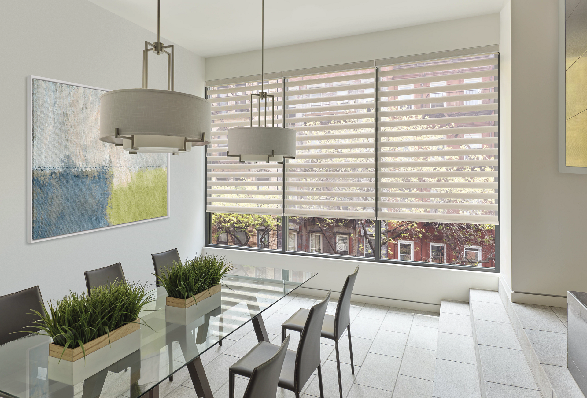 A dining room with a glass table and chairs and a large window.