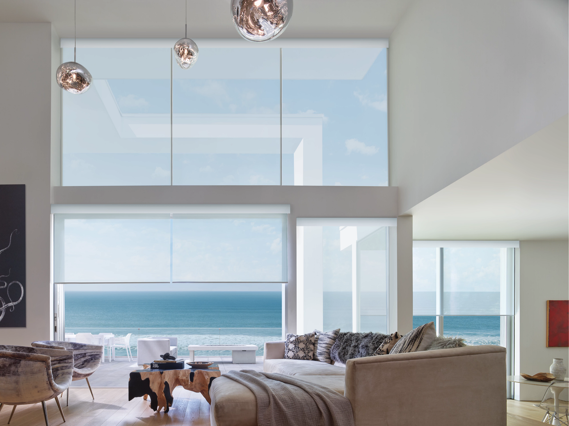 A living room with a large window overlooking the ocean.