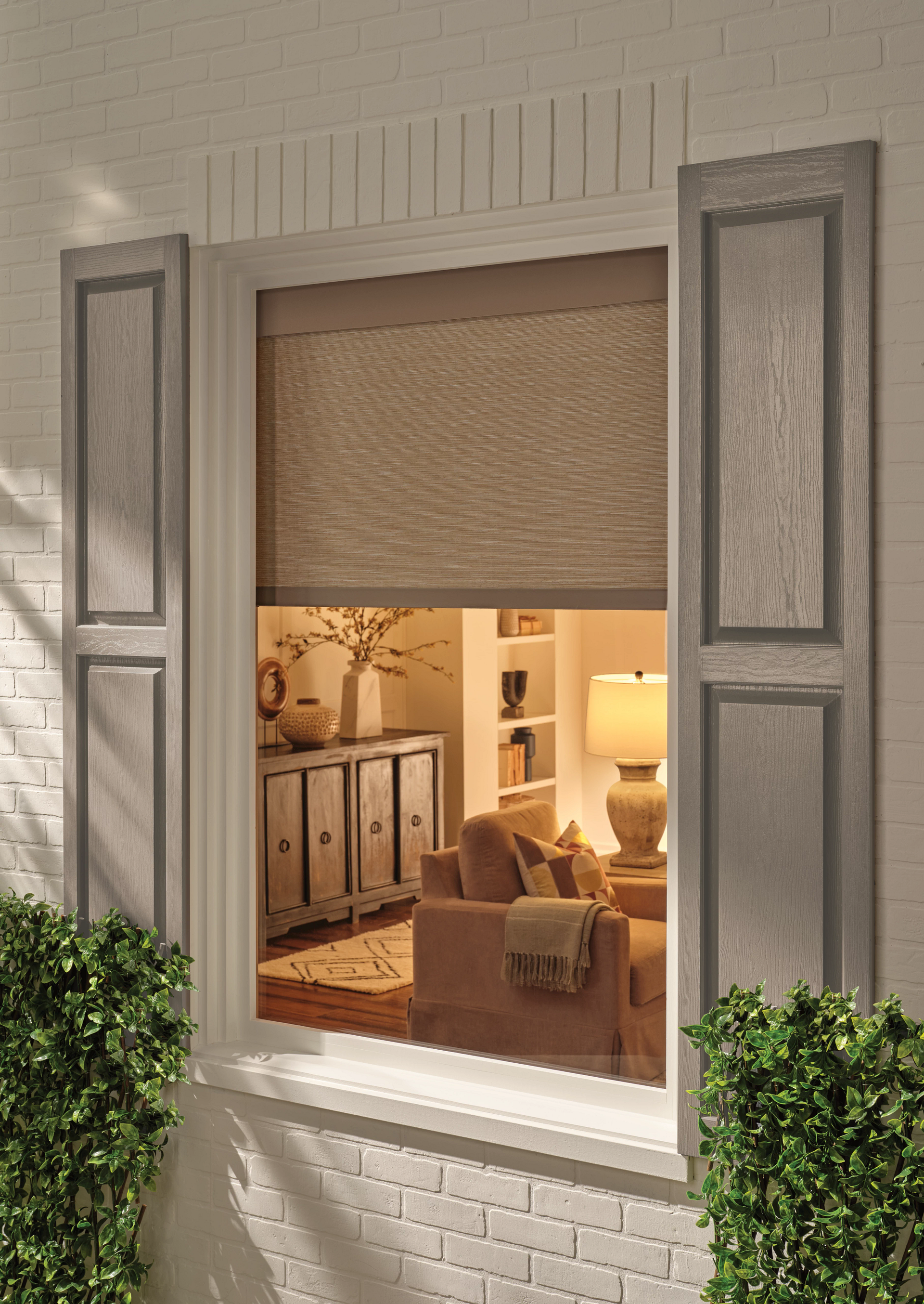 A window with a blind on it is open to a living room.