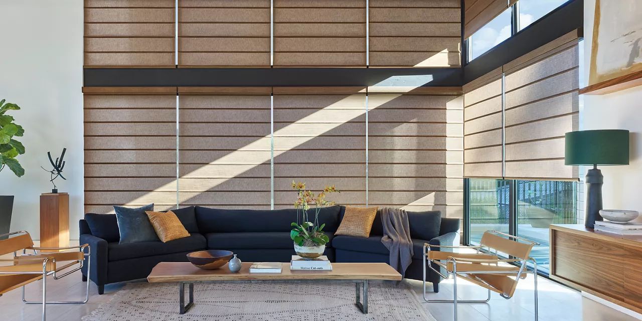 A living room with a couch, table, chairs, and blinds.