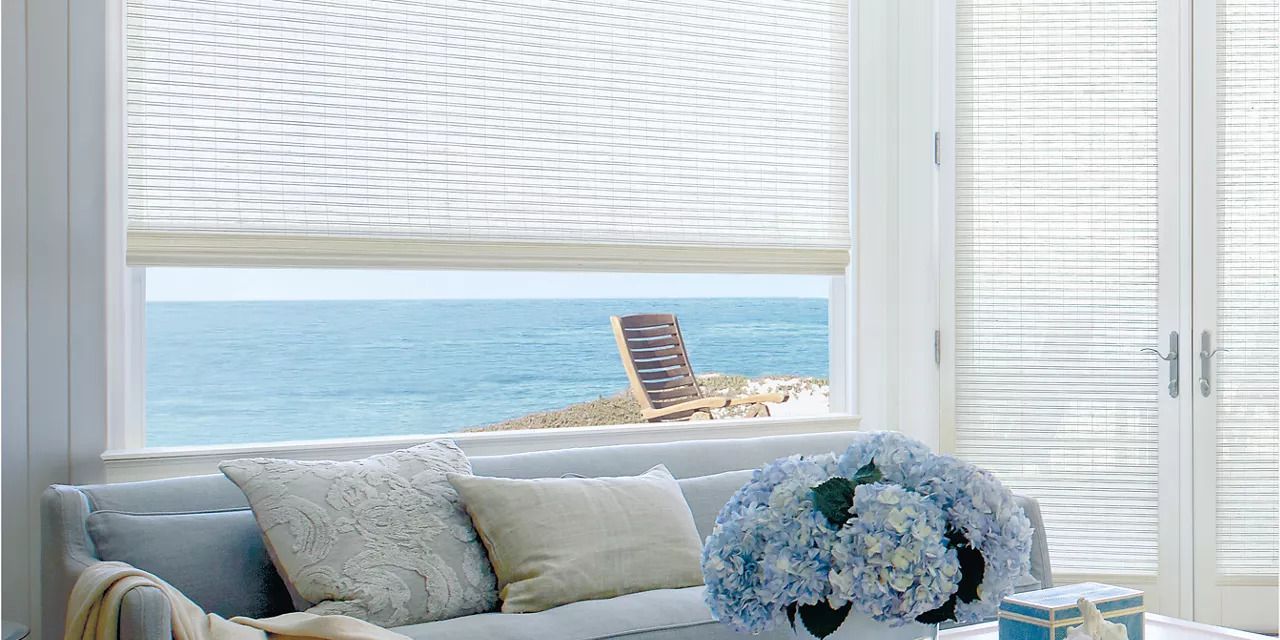 A living room with a couch and a window with a view of the ocean.