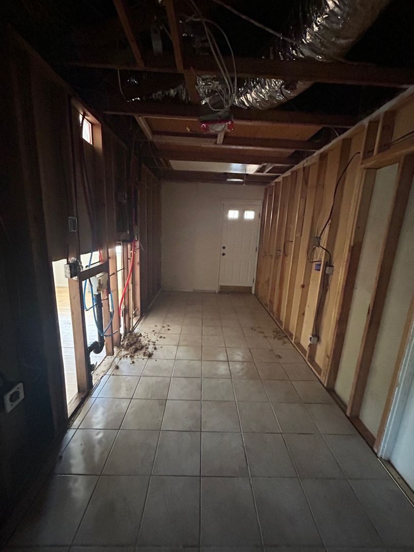 An empty room with wooden walls and a tiled floor.