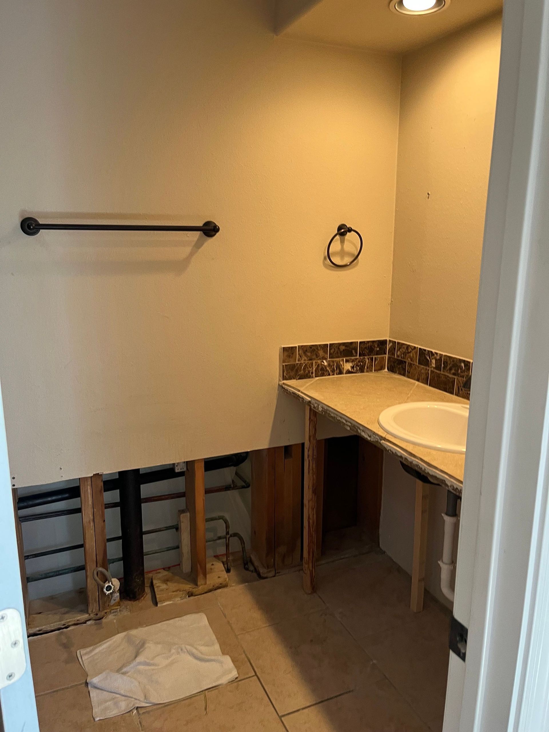 A bathroom with a sink and a towel rack.
