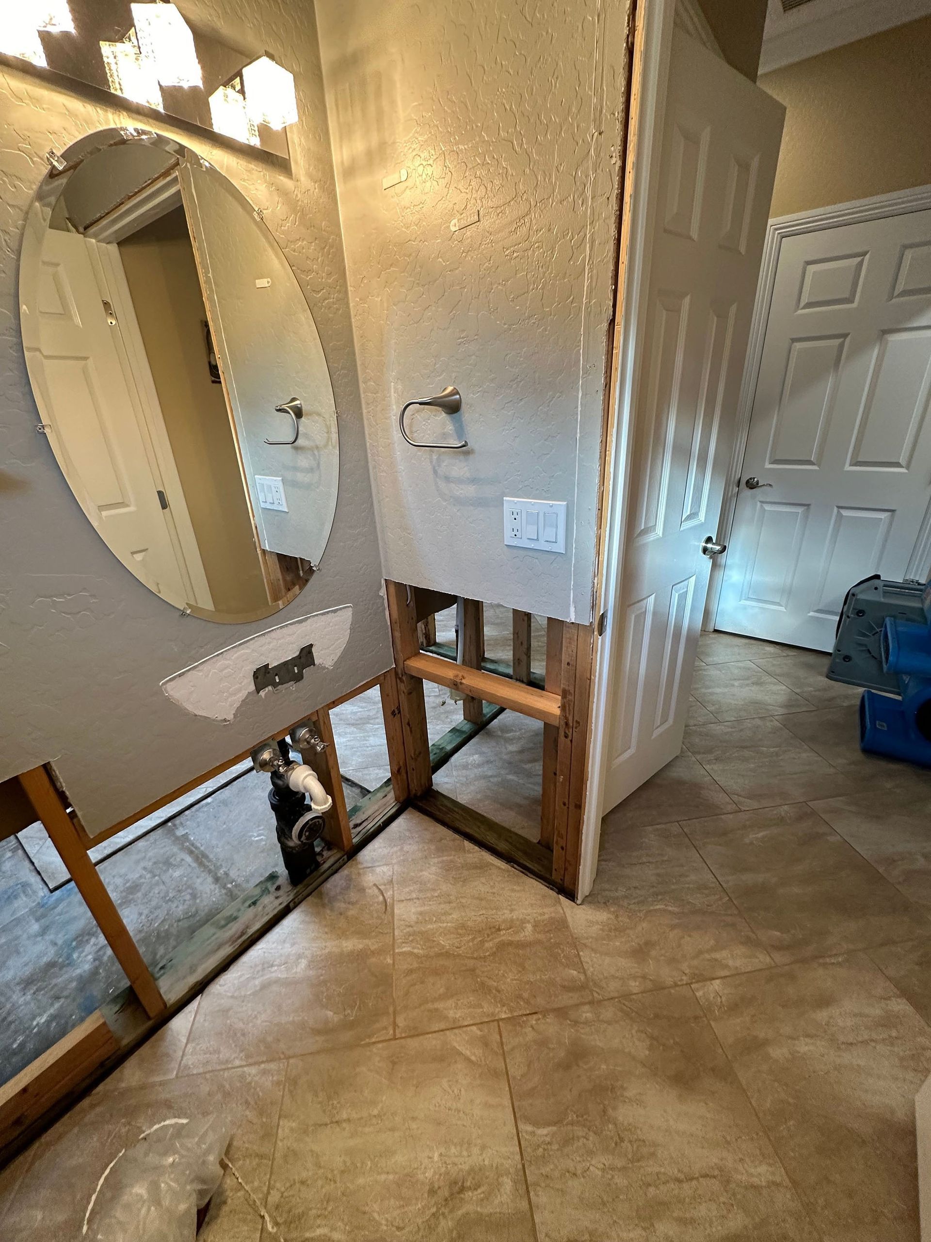 A bathroom with a sink and a mirror being remodeled.