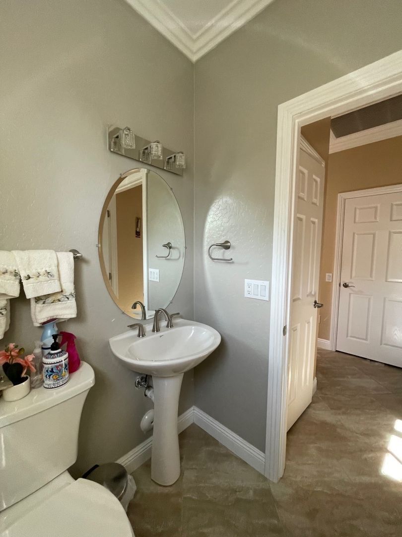 A bathroom with a toilet , sink and mirror