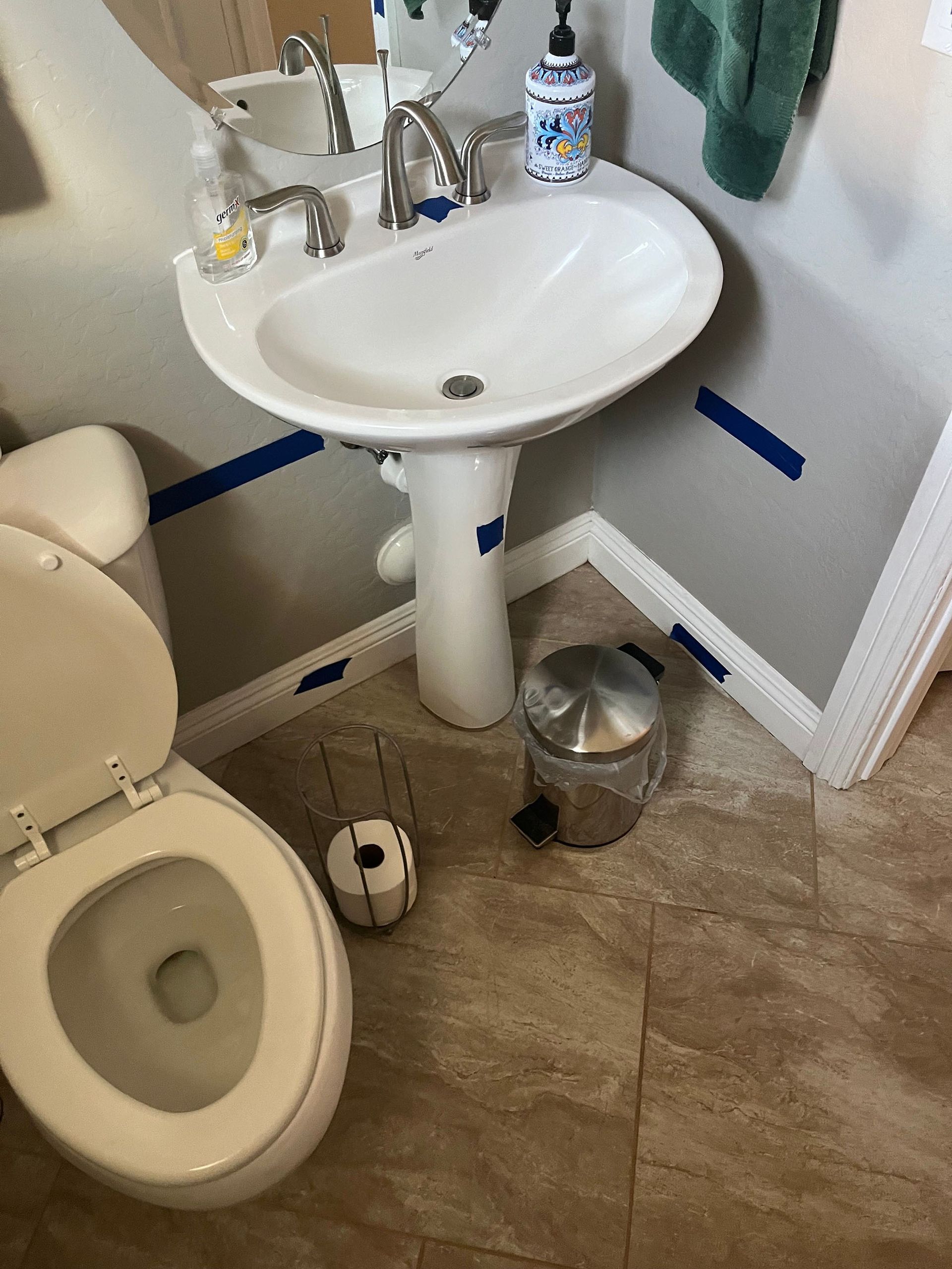 A bathroom with a toilet a sink and a mirror