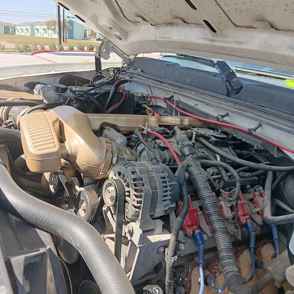 Open engine bay with exposed wiring, hoses, and components under a raised hood.