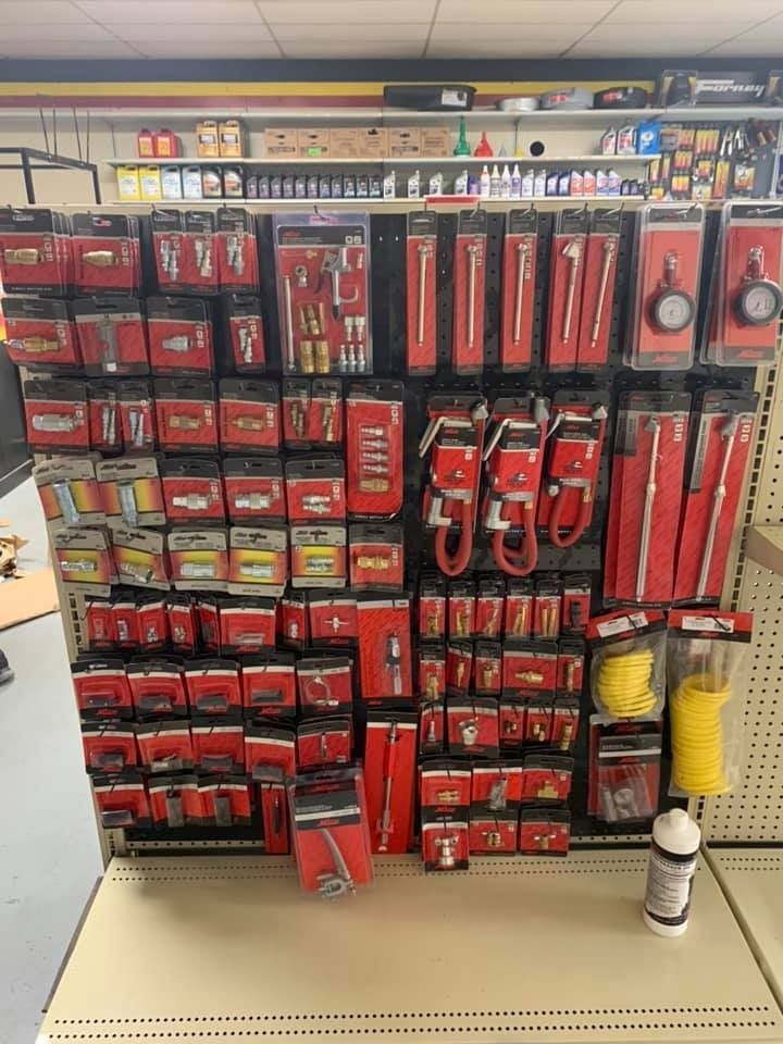 A bunch of tools are hanging on a wall in a store.
