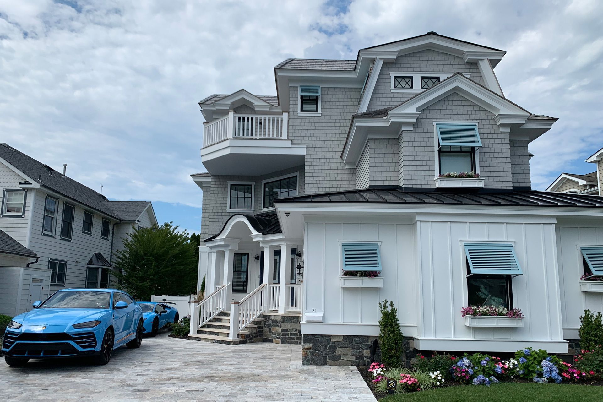 newly-constructed white house with blue cars parked outside