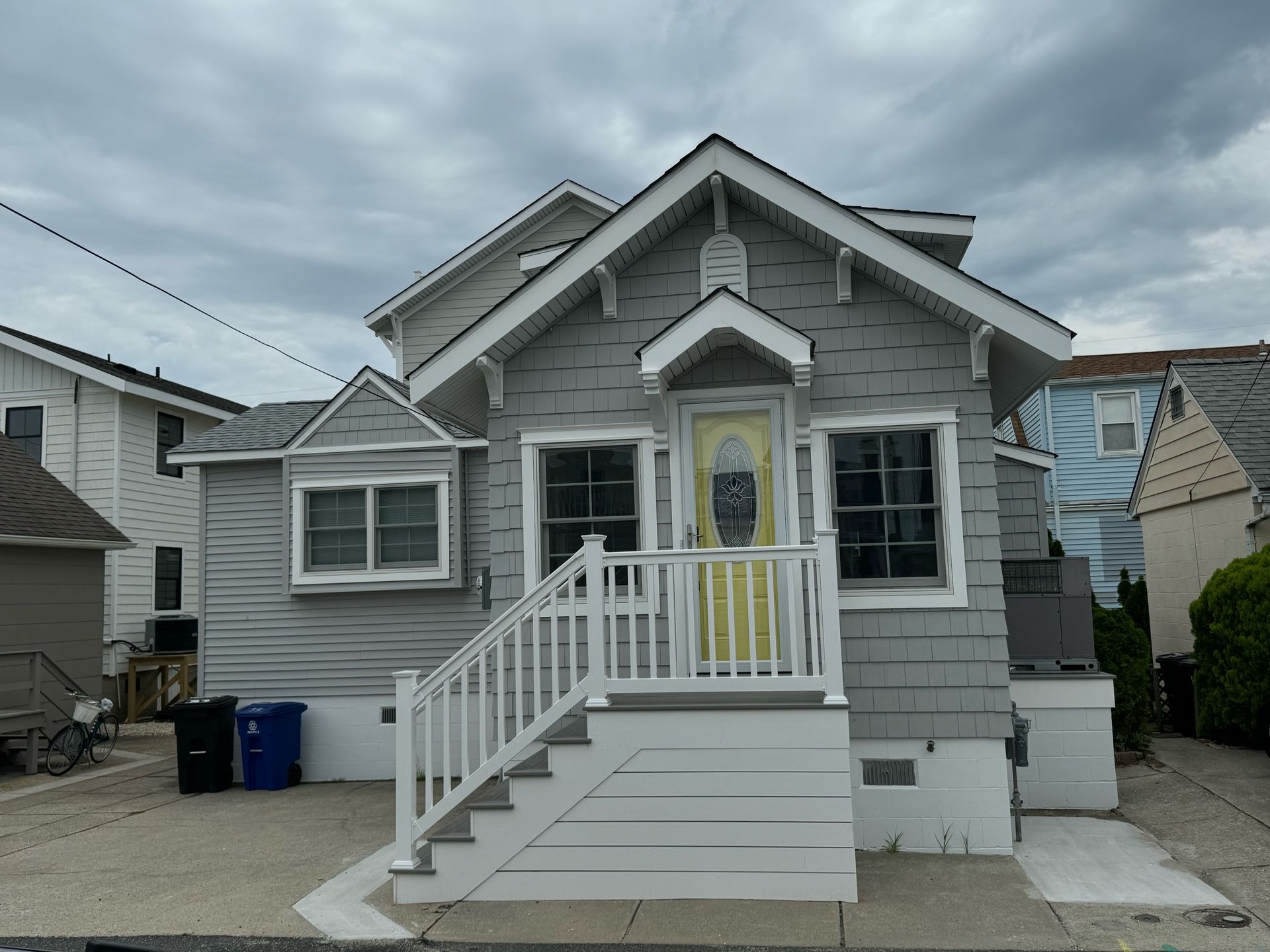 A small house with a yellow door and white stairs
