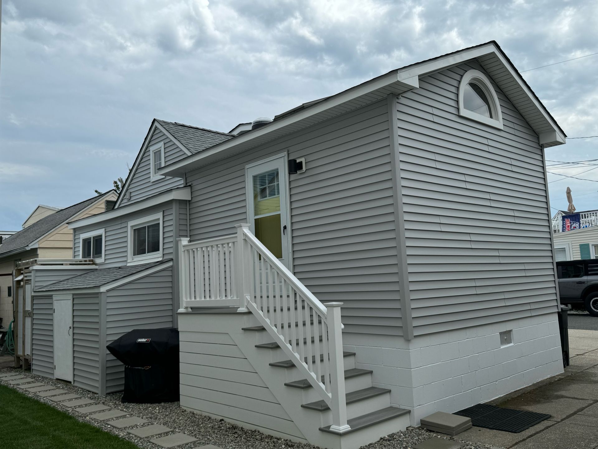 A small house with stairs leading up to the front door