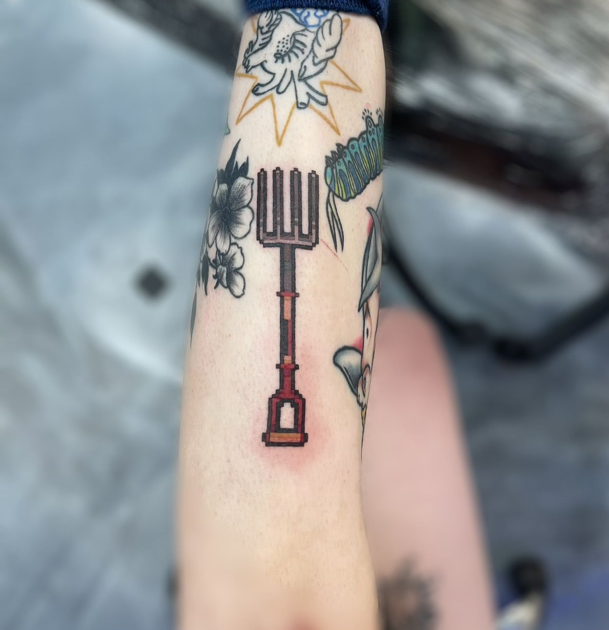 Tattoo of a pixelated kunai knife