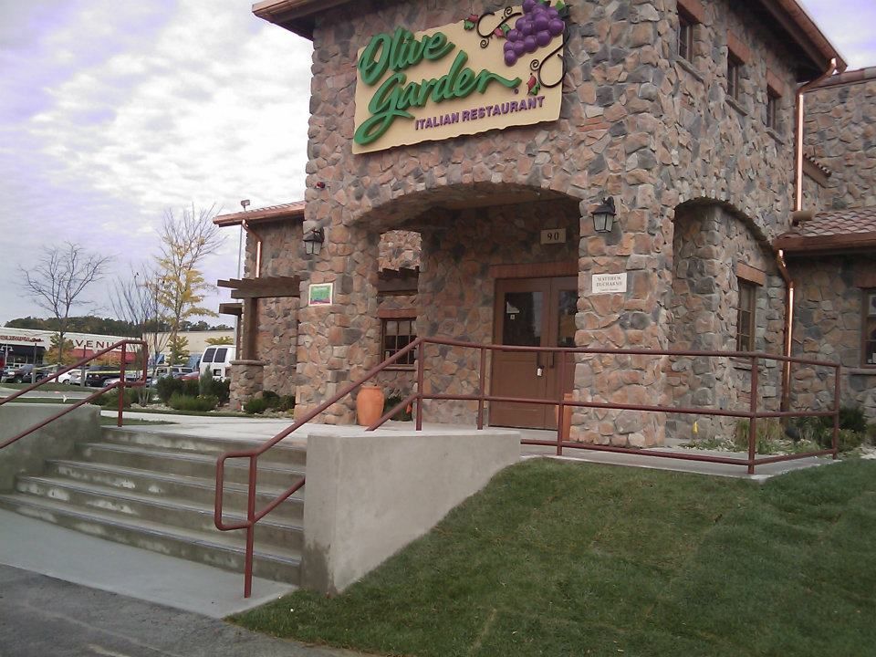 Stone building entrance with stairs, ramp, and a sign reading “Olive Garden”