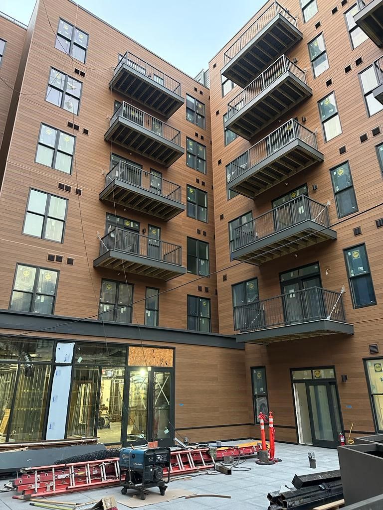 Brick apartment courtyard with balconies above and outdoor seating below