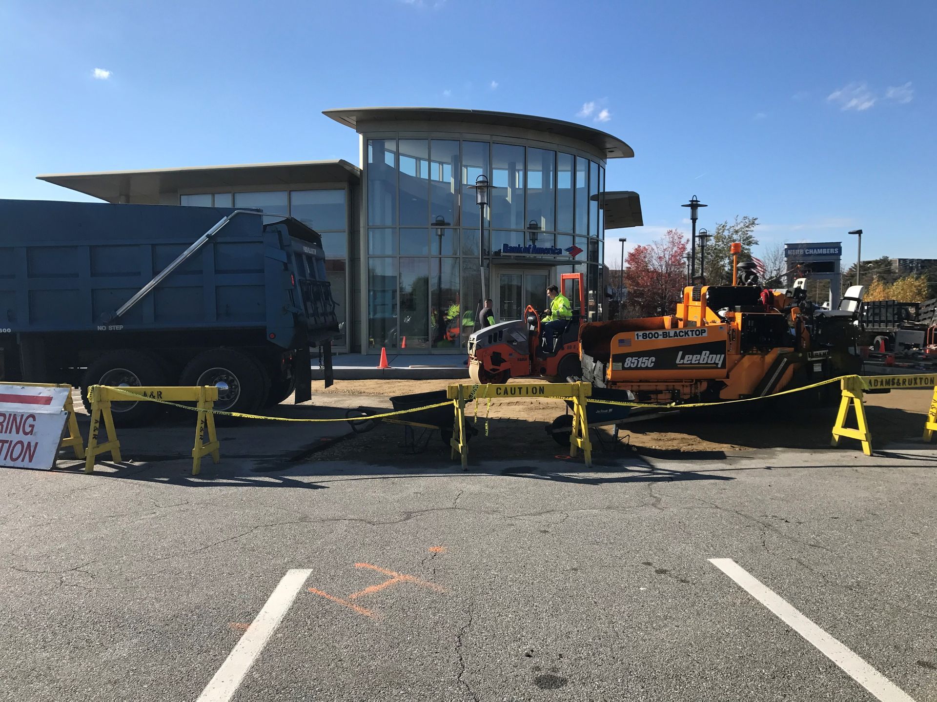 A dump truck is parked in a parking lot in front of a building