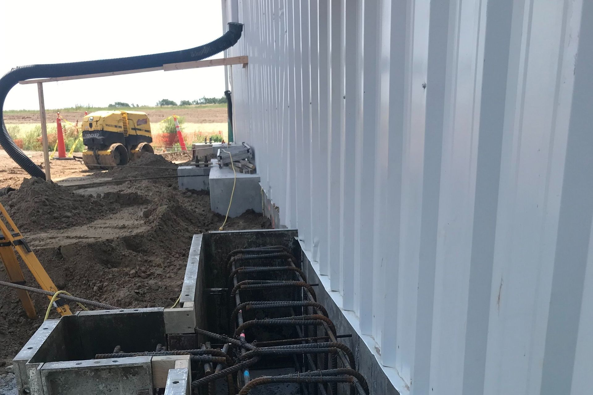 A construction site with a building under construction and a bulldozer in the background.