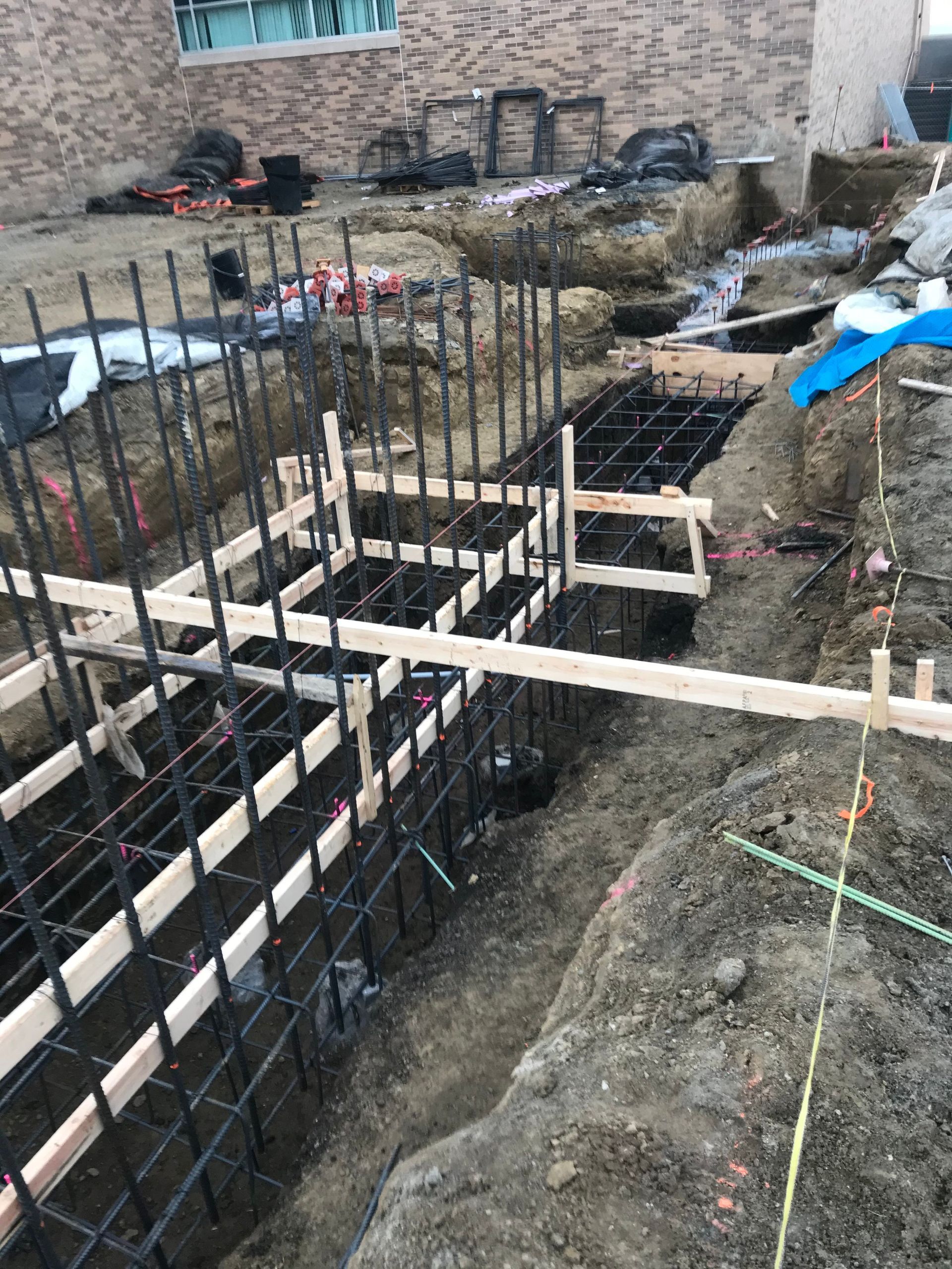 A fence is being built in the dirt in front of a building.